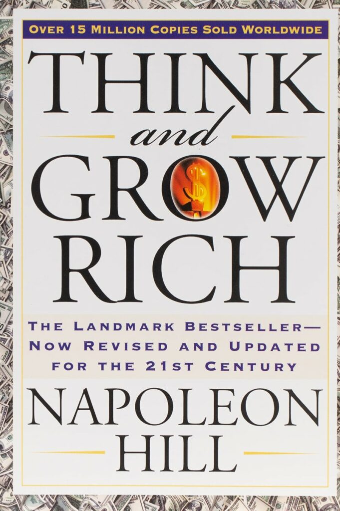 Cover of the book Think and Grow Rich by Napoleon Hill with the title in large black letters and images of dollar bills in the background.